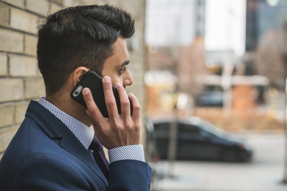 Man in a suit on a phone call outside an office building