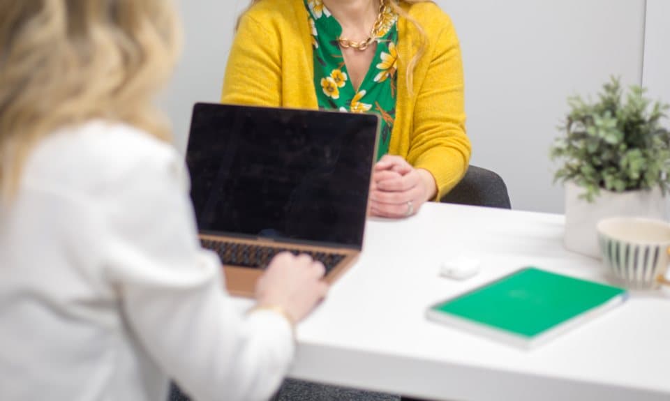 Recruiter interviewing a candidate across a bright desk