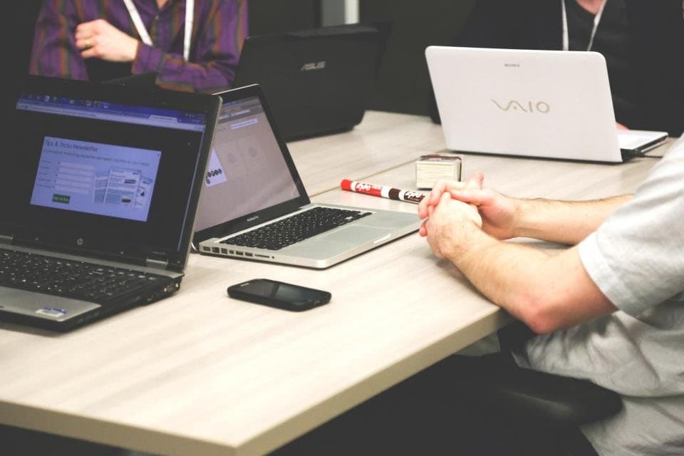 Laptops open on a conference table during a working session